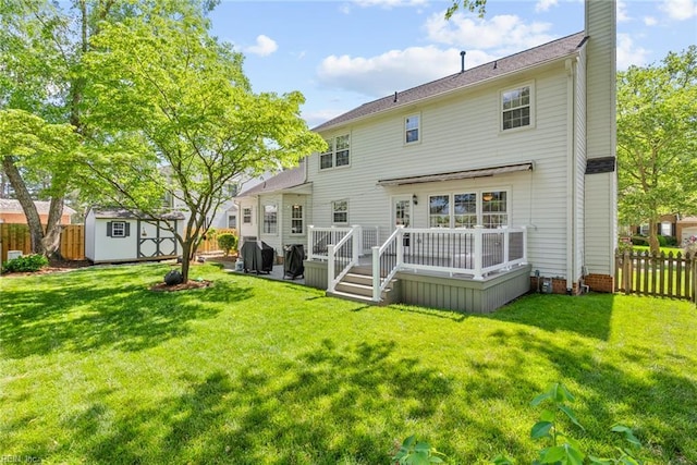 back of property with a storage unit, a deck, an outdoor structure, and a chimney
