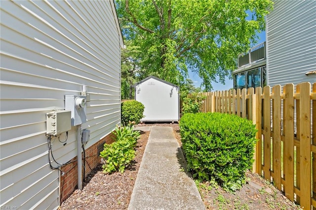 view of yard featuring a shed, fence, and an outdoor structure