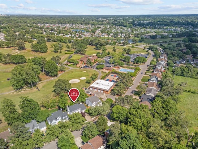 aerial view of property and surrounding area featuring nearby suburban area and a golf course