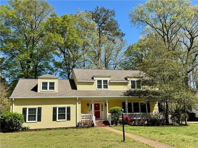 view of front of property featuring covered porch, a front lawn, and roof with shingles
