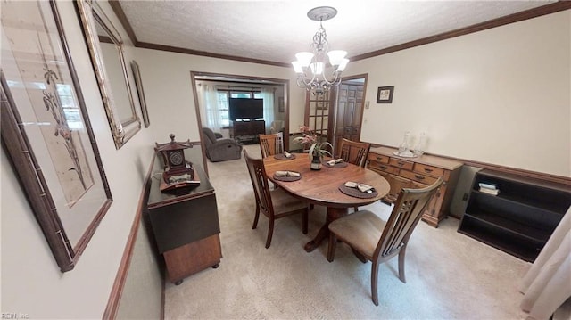 dining space with light colored carpet, a chandelier, ornamental molding, and a textured ceiling