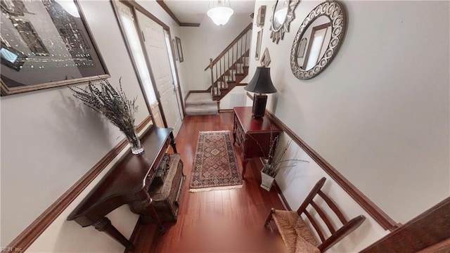 entrance foyer with wood finished floors, stairs, and ornamental molding