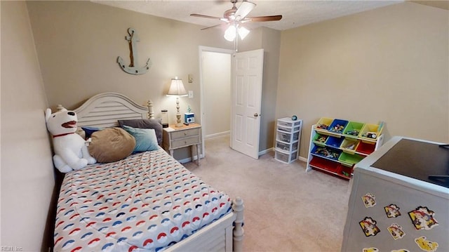 bedroom featuring light colored carpet, ceiling fan, and baseboards