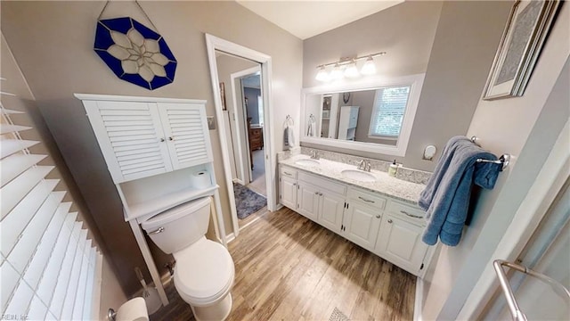 bathroom featuring toilet, wood finished floors, and vanity