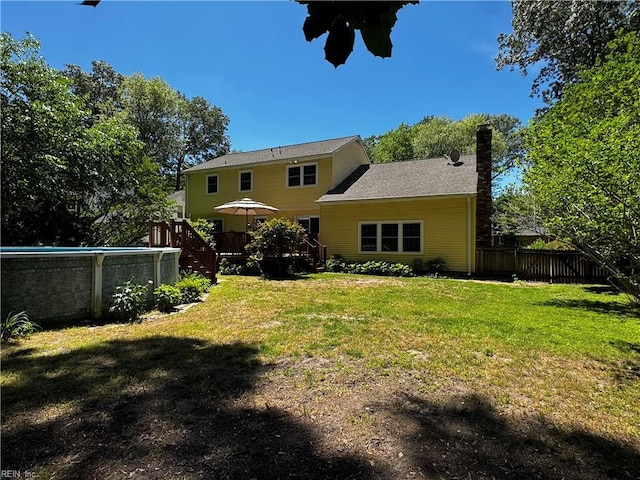 rear view of property with a deck, a chimney, and stairway
