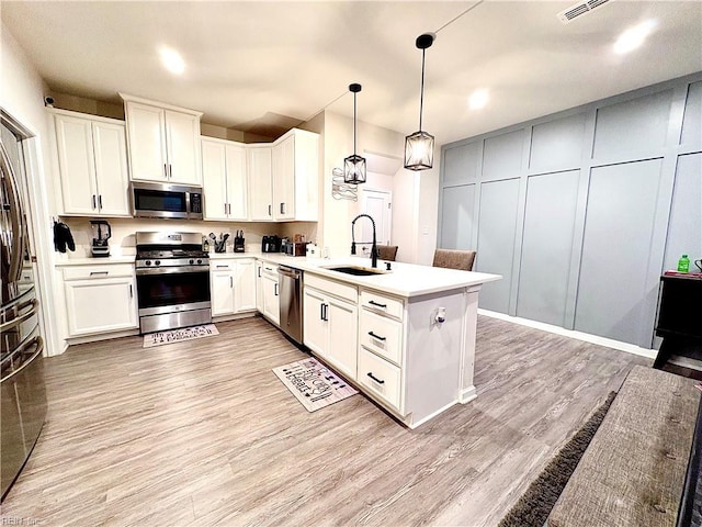 3432 Foxglove Dr, Toano, VA 23168 - kitchen with stainless steel appliances, a sink, a peninsula, light wood-type flooring, and light countertops