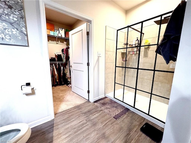 3432 Foxglove Dr, Toano, VA 23168 - bathroom featuring wood finished floors, a tile shower, toilet, a spacious closet, and baseboards