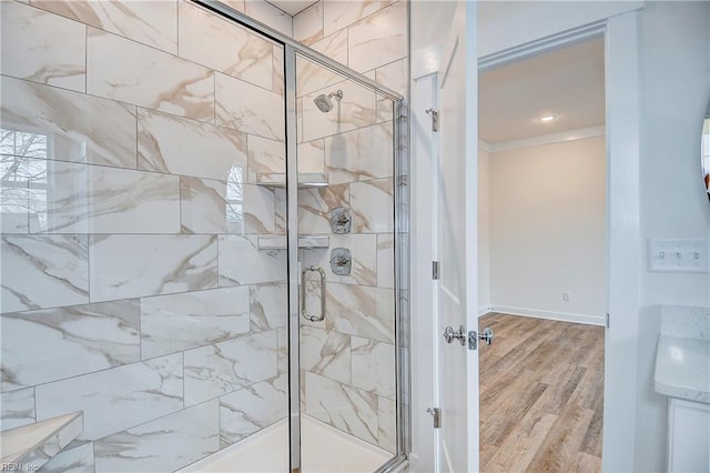 full bath with crown molding, baseboards, wood finished floors, and a shower stall