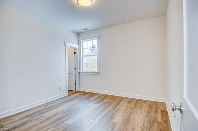unfurnished room with light wood-style flooring and baseboards