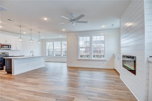 unfurnished living room featuring light wood-type flooring, visible vents, recessed lighting, a large fireplace, and ceiling fan
