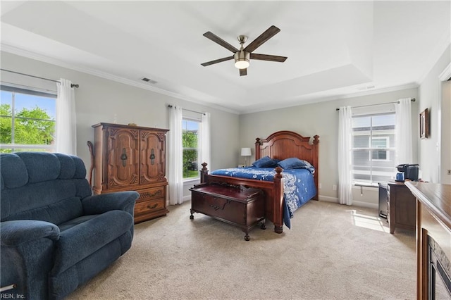 bedroom featuring a tray ceiling, light carpet, crown molding, and ceiling fan