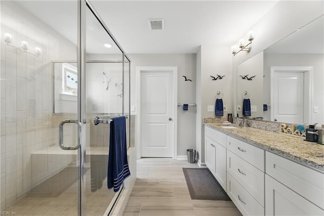 bathroom with a shower stall, vanity, baseboards, and recessed lighting