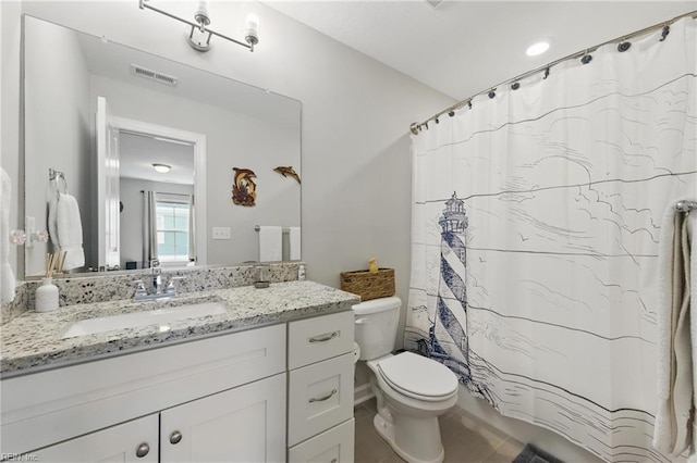 bathroom featuring toilet, vanity, a shower with shower curtain, and tile patterned floors