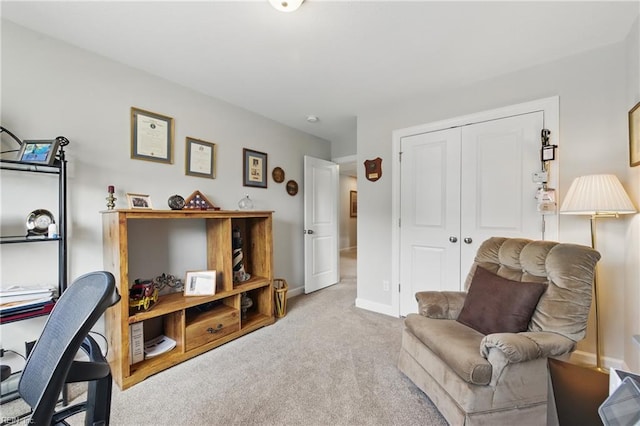 sitting room with carpet flooring, baseboards, and a desk