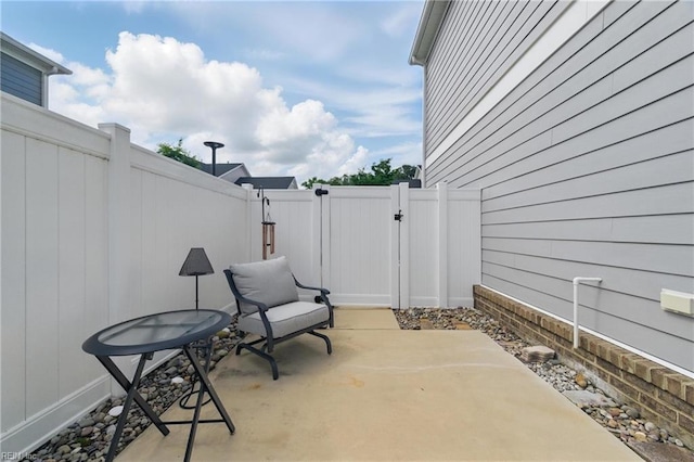 view of patio featuring fence and a gate