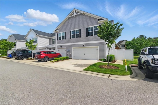 view of front of house featuring an attached garage, fence, and driveway