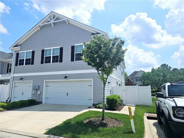 view of front of house featuring an attached garage, driveway, and fence