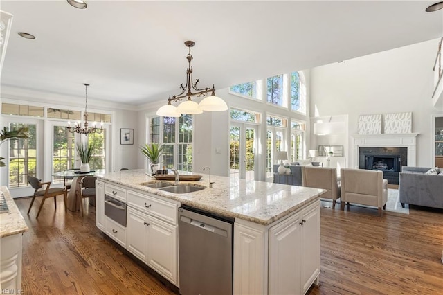 kitchen featuring dishwasher, a sink, white cabinetry, healthy amount of natural light, and ornamental molding