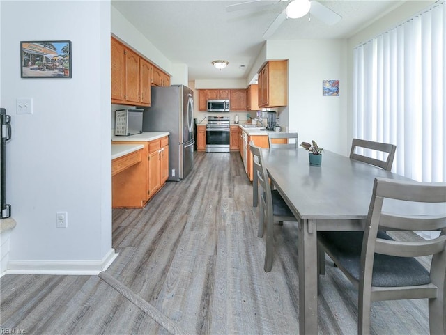 1242 Woods Edge Cir, Suffolk, VA 23434 - dining area with light wood-style flooring, ceiling fan, and baseboards