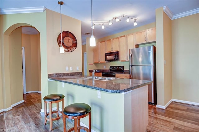 1400 Granby St Unit 309, Norfolk, VA 23510 - kitchen with black appliances, a sink, light brown cabinetry, a breakfast bar, and light wood-type flooring