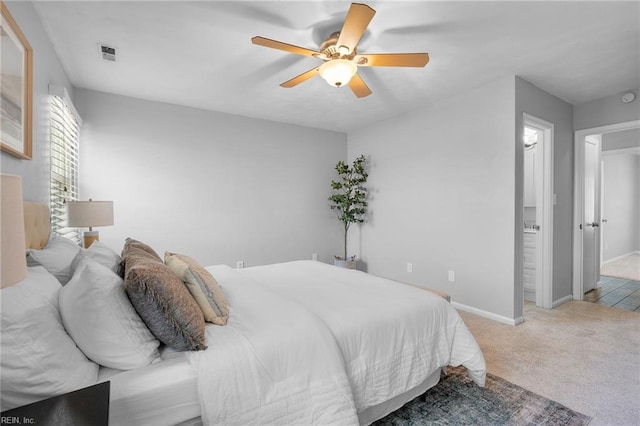 bedroom featuring carpet floors, baseboards, ceiling fan, and connected bathroom