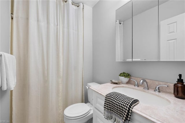 bathroom with toilet, vanity, and a shower with shower curtain