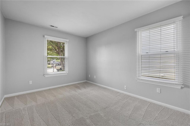 carpeted empty room featuring baseboards