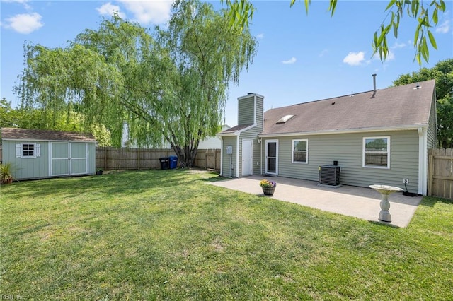 back of house with a patio area, a shed, a chimney, an outbuilding, and central AC unit