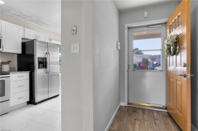 entryway featuring baseboards and light wood-style flooring