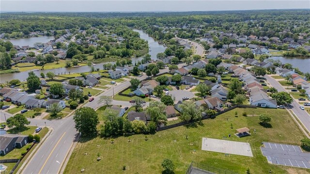 aerial view of property and surrounding area featuring a large body of water and nearby suburban area