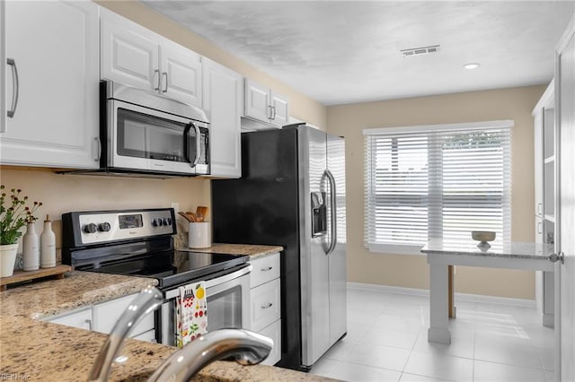 kitchen with appliances with stainless steel finishes, white cabinetry, baseboards, light stone countertops, and recessed lighting