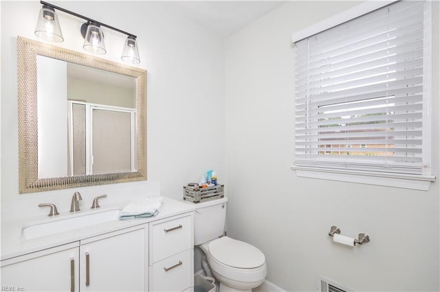 bathroom with toilet, vanity, and a stall shower