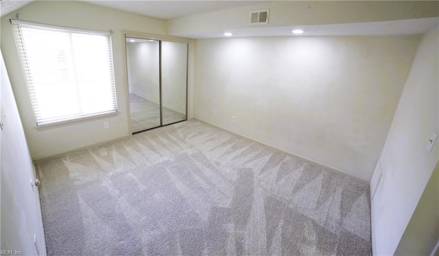 unfurnished bedroom with carpet, recessed lighting, and a closet