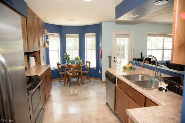 1132 Van Loen Dr, Virginia Beach, VA 23453 - kitchen with appliances with stainless steel finishes, a sink, baseboards, light countertops, and brown cabinetry