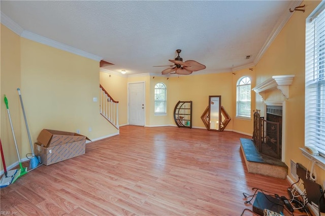 4813 Shallowford Cir, Virginia Beach, VA 23462 - unfurnished living room featuring a fireplace with raised hearth, stairs, light wood-style floors, ornamental molding, and a ceiling fan