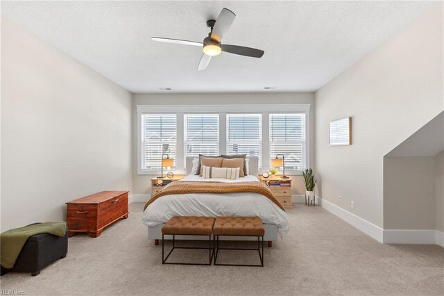 bedroom with carpet flooring, multiple windows, baseboards, and a textured ceiling