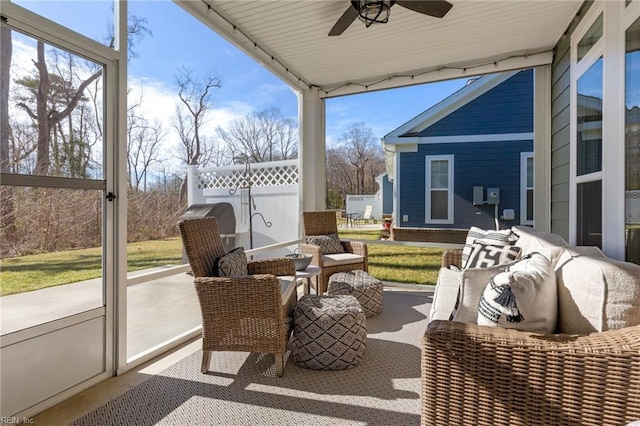 sunroom with ceiling fan, rail lighting, and healthy amount of natural light