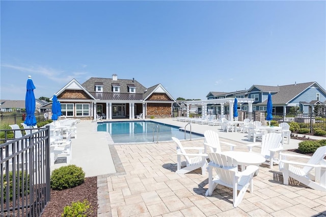 community pool with a pergola, fence, and a patio area