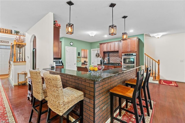 2234 Creekway Dr, Smithfield, VA 23430 - kitchen with appliances with stainless steel finishes, arched walkways, dark wood-style flooring, a kitchen bar, and recessed lighting
