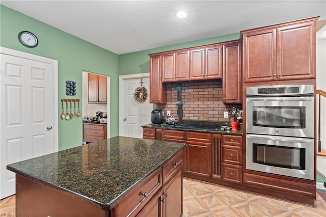 2234 Creekway Dr, Smithfield, VA 23430 - kitchen with stainless steel double oven, decorative backsplash, a textured ceiling, dark stone counters, and recessed lighting