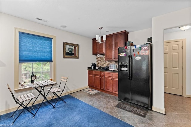 2234 Creekway Dr, Smithfield, VA 23430 - kitchen featuring black refrigerator with ice dispenser, stainless steel microwave, dark tile patterned flooring, and decorative backsplash