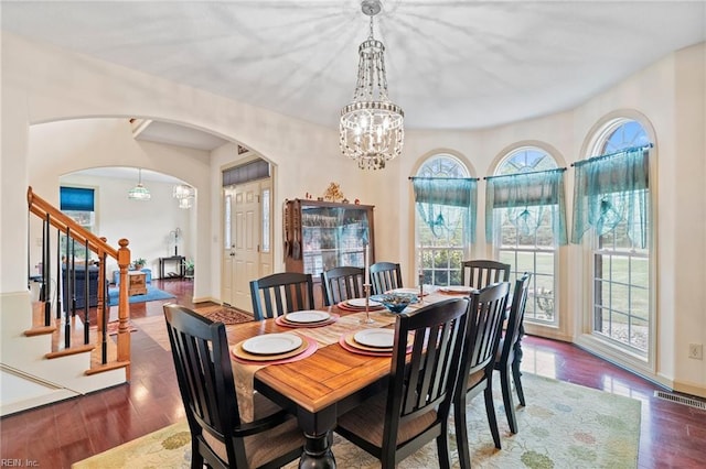 2234 Creekway Dr, Smithfield, VA 23430 - dining room featuring arched walkways, a chandelier, stairs, wood finished floors, and baseboards