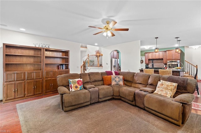2234 Creekway Dr, Smithfield, VA 23430 - living area featuring stairway, arched walkways, ceiling fan, and light wood-style flooring
