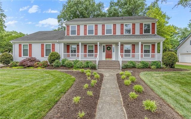 colonial inspired home featuring a porch and a front lawn