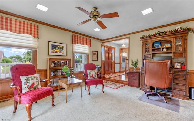 office area with carpet floors, healthy amount of natural light, ornamental molding, ceiling fan, and wainscoting