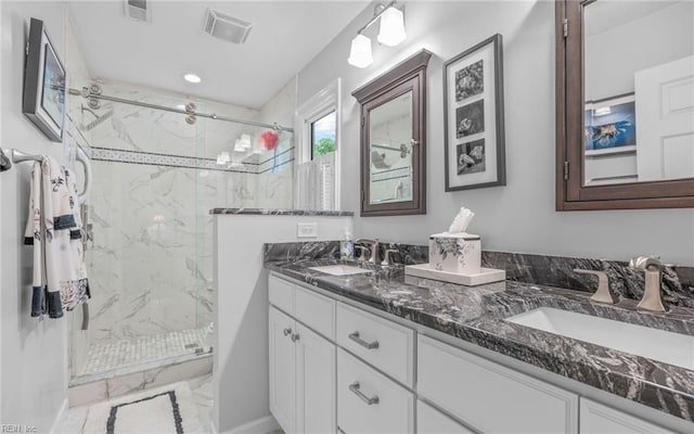 bathroom with a marble finish shower, double vanity, marble look tiles, and recessed lighting