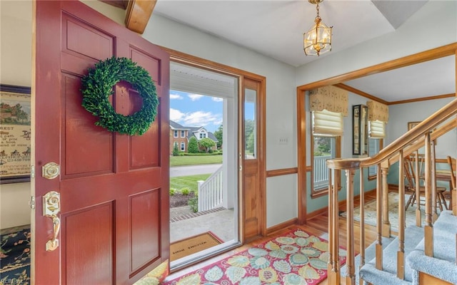 entrance foyer with stairway, a chandelier, baseboards, and wood finished floors