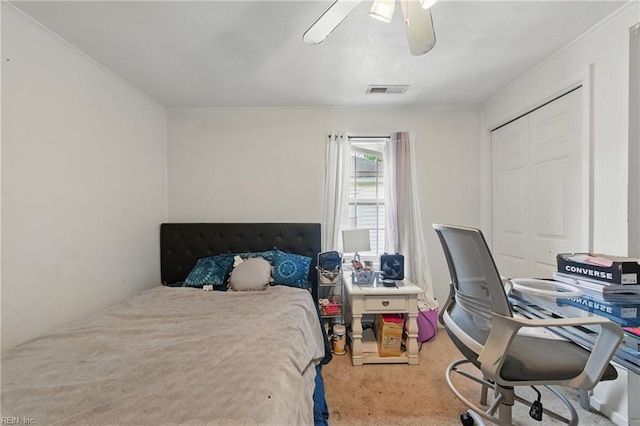 bedroom featuring carpet floors, ceiling fan, ornamental molding, and a closet