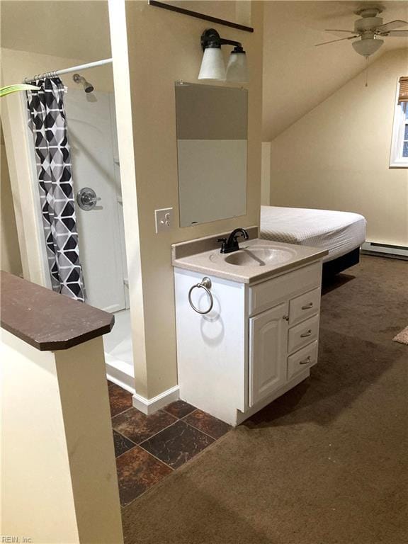 bathroom featuring a stall shower, baseboard heating, a ceiling fan, vanity, and baseboards