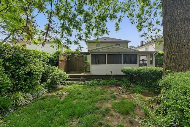 back of property featuring a sunroom and fence
